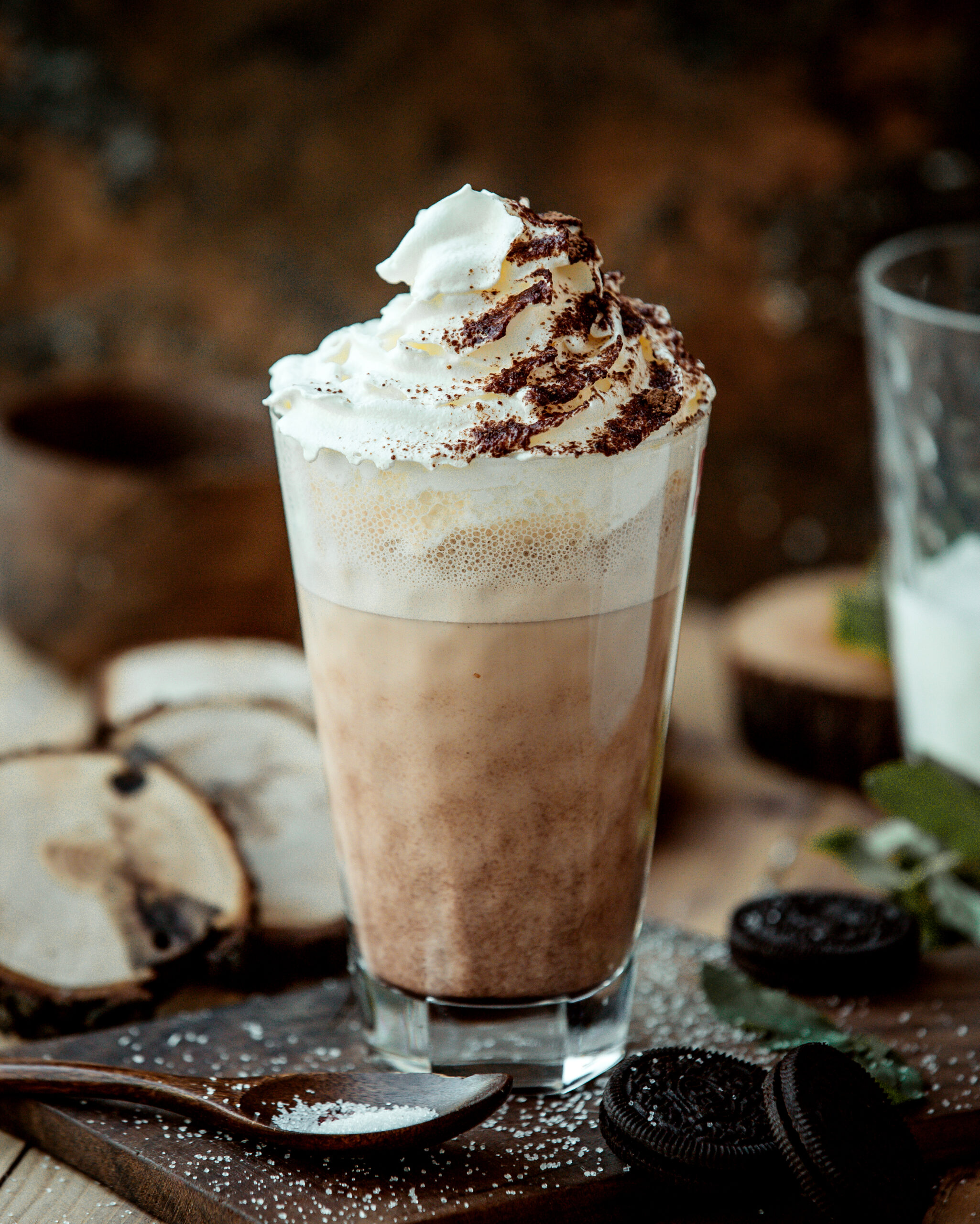 a cup of coffee with whipped cream and coffee sprinkles